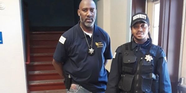 Two security personnel posing indoors.