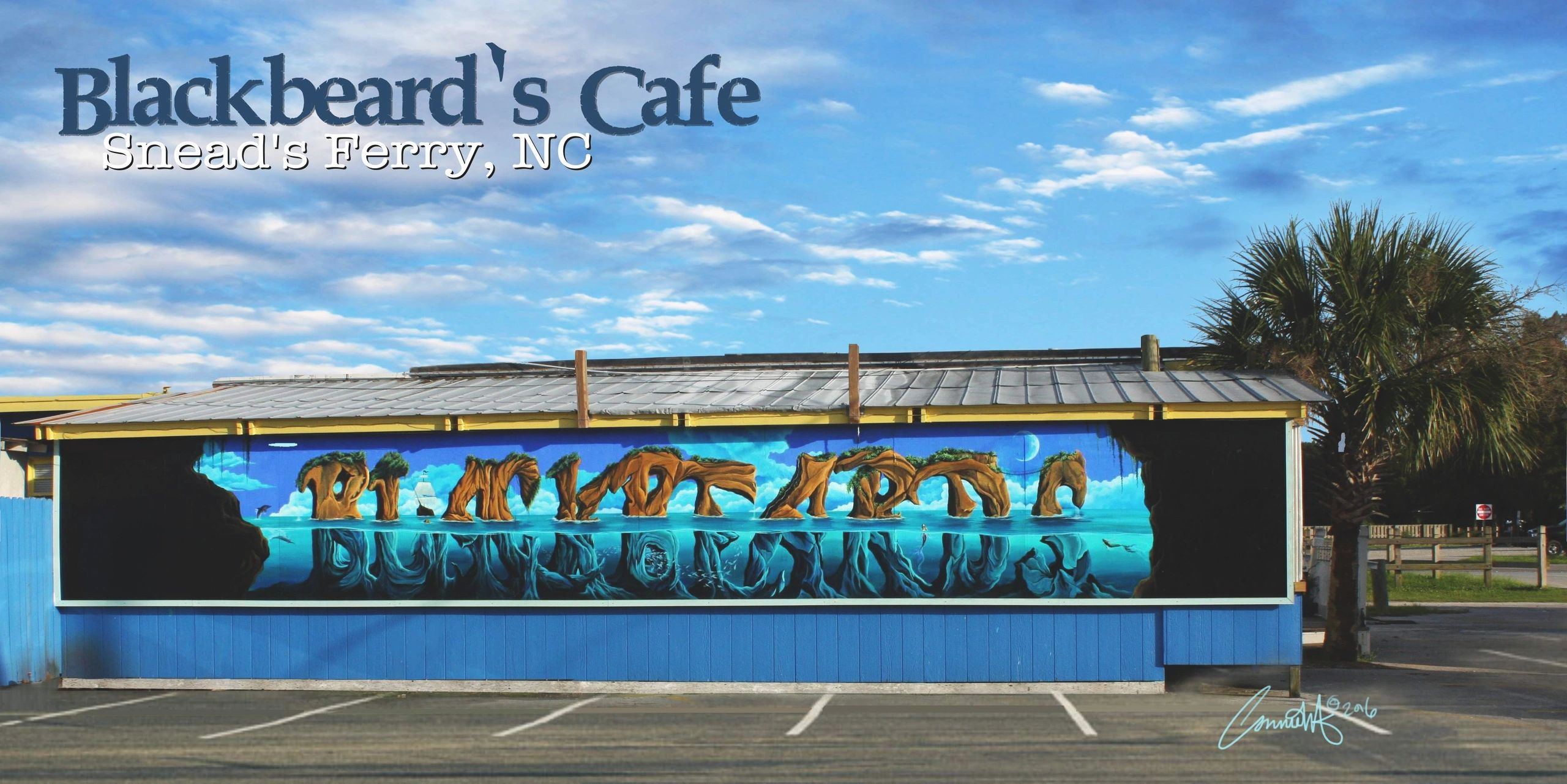 Exterior mural of the word "Blackbeards" made of stone and half submerged in ocean