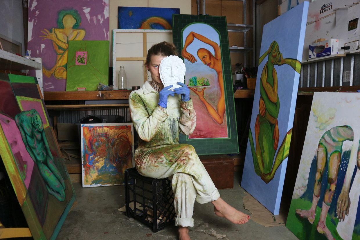 Contemporary emerging Adelaide artist Caitlin Mohr in studio of colourful figurative oil paintings. 