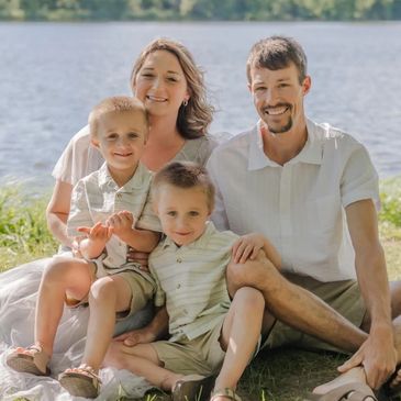 Happy family of four sitting by the water.