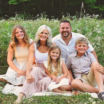 Happy family sitting outdoors on the grass.