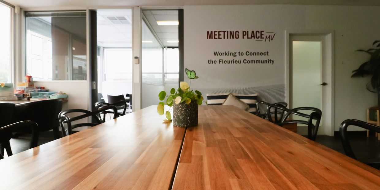 Empty community meeting room with a wooden table and plant centerpiece.