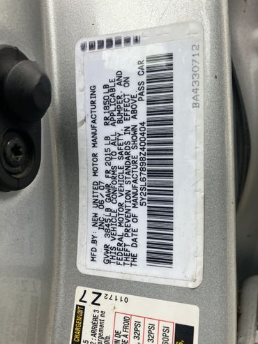 Car manufacturing label with weight and safety information.