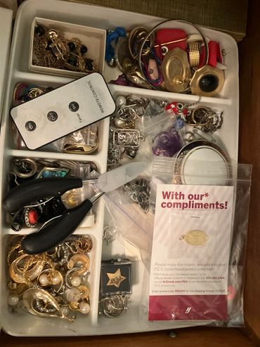 Organized jewelry box with tools, rings, earrings, and a complimentary charm package.