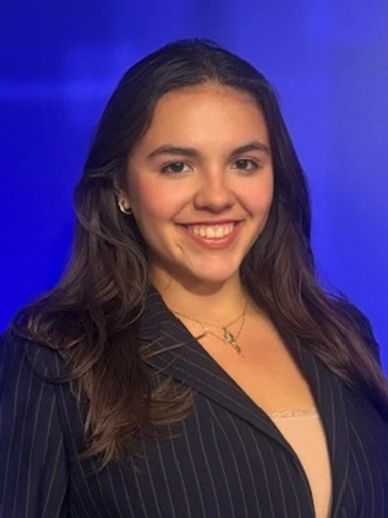 Young woman smiling in a pinstripe blazer.