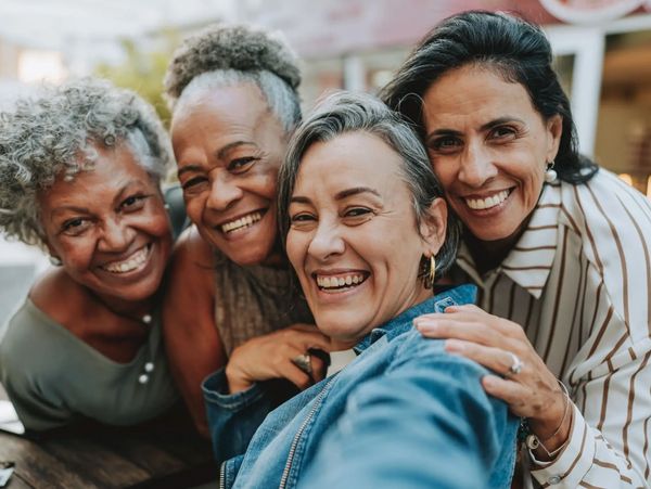 Five diverse women smiling and looking at the camera.