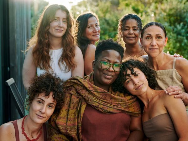 Diverse group of five happy women in warm lighting.