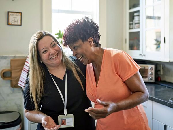 Two women collaborating and looking at a digital device.