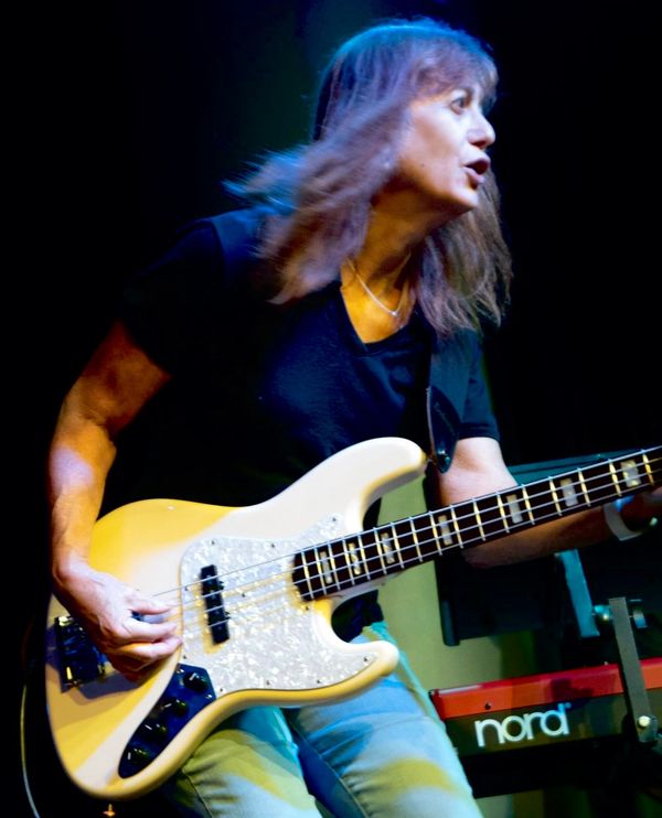 Andrea playing bass guitar on stage