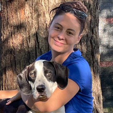 Sahvanna and her dog sitting in front of a tree.