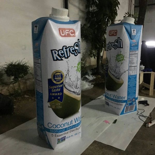 Two UFC Refresh coconut water cartons on a table outdoors.