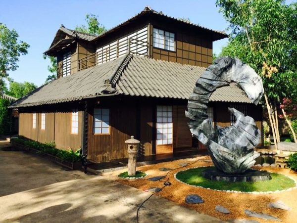 Traditional Japanese-style house with a modern sculpture in the garden.