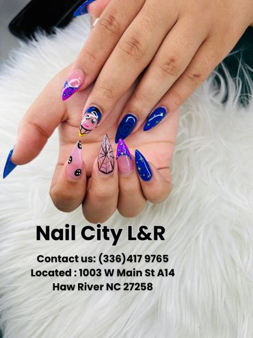 Colorful, detailed nail art with various designs on a fluffy white surface.