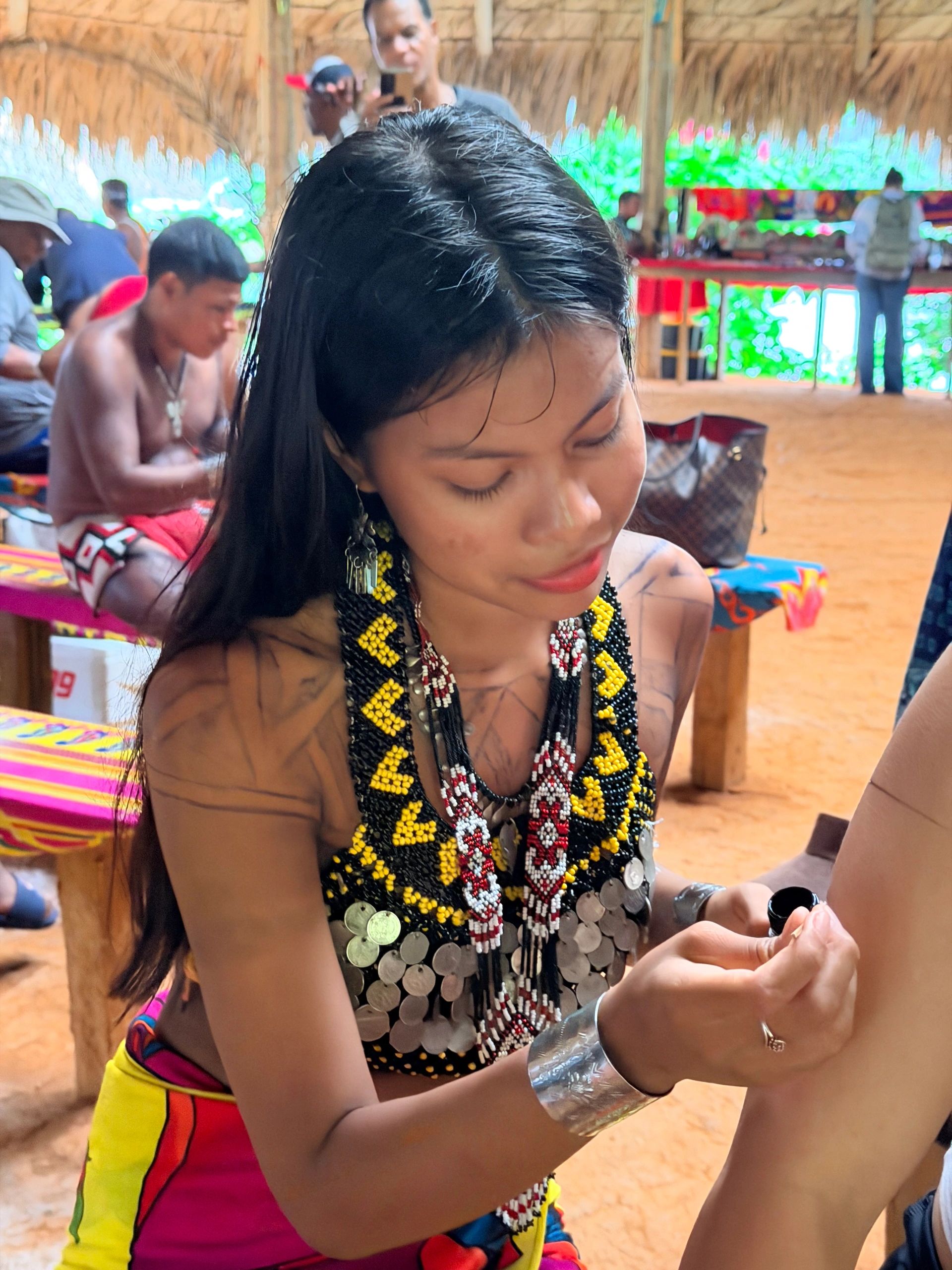 An young Embera painting a traditional temporary ink tattoo on a guest