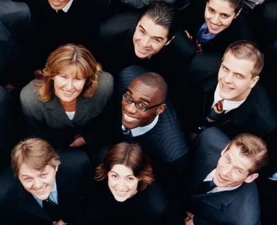 Diverse group of professionals smiling and looking up at the camera.