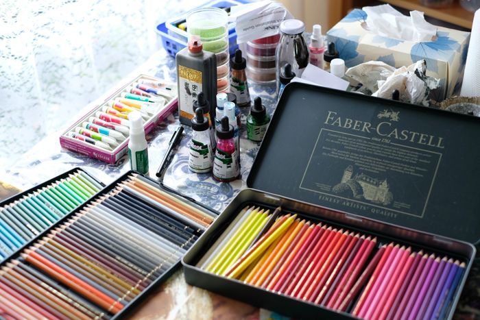 Art material, inks, colour pencils lying on the table