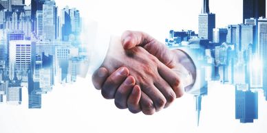 Two hands shaking with a cityscape overlay symbolizing business partnership.