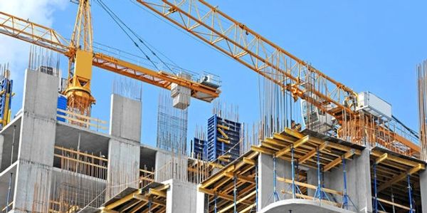 Construction site with cranes and building framework.
