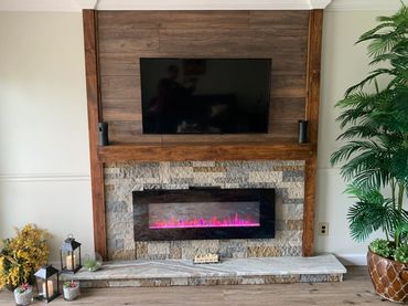 Modern living room setup with a wall-mounted TV and electric fireplace.