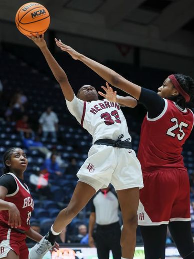 Basketball player in white jersey scoring over defender in red jersey during intense game.