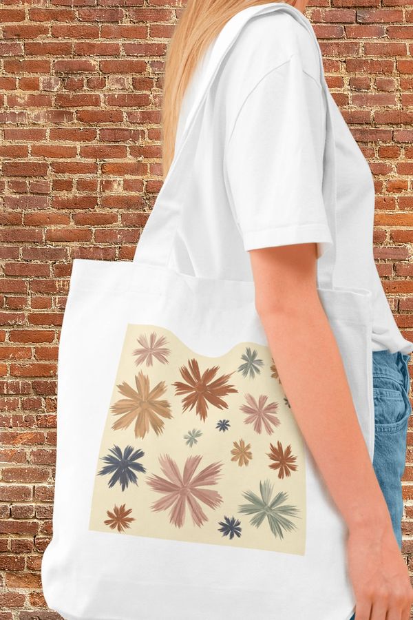 A woman carrying a tote bag with whimsical floral design.