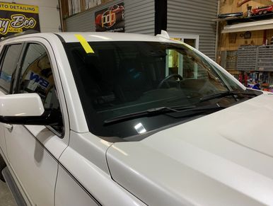 White vehicle inside a garage with detailing banners.
