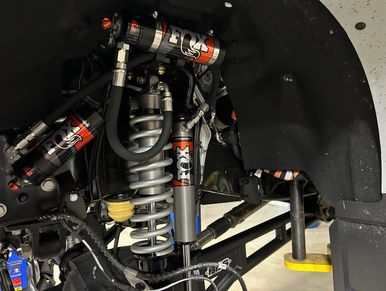 Close-up of a FOX suspension system on a vehicle's wheel assembly.