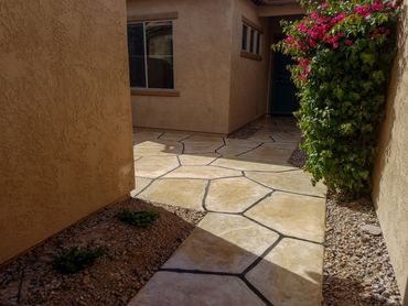 decorative concrete walkway with begonia bush on righthand side