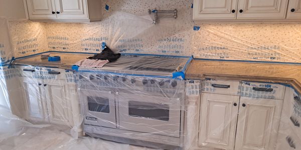 Modern kitchen in protective sheeting covering floors during stone countertop restoration