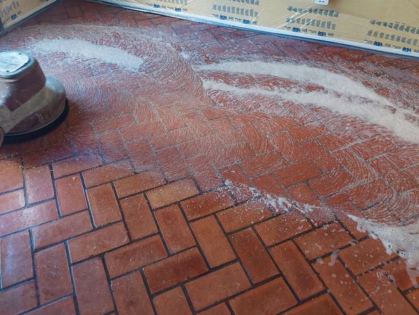 Cleaning, polishing, and refinishing southwestern style red brick in residential home