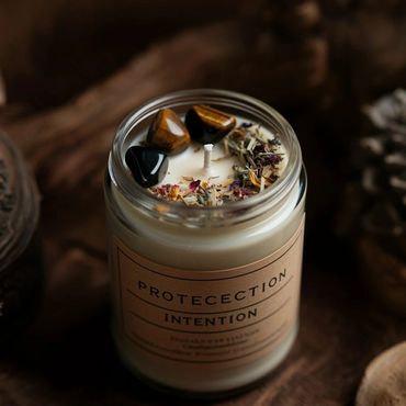 A protection intention candle decorated with stones and dried flowers.