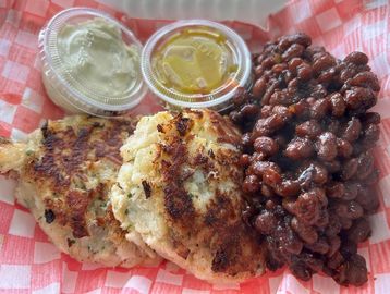 Crab cakes with baked beans and sauces.