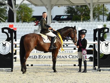 Two equestrians with horse at World Equestrian Center with awards.