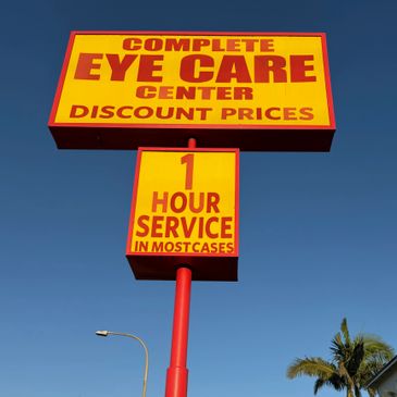 Bright yellow and red sign for an eye care center with discount prices and quick service.