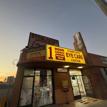 Eyeglasses and eye care center with bright signs at dusk.