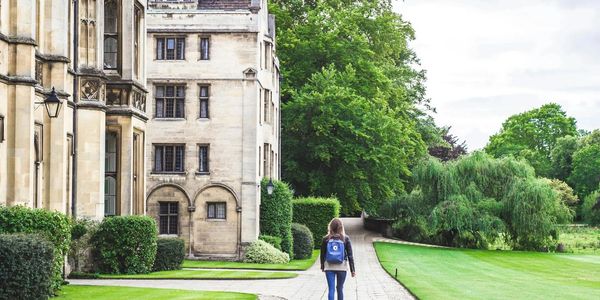 Student walking in front of a Cambridge University college
