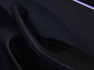 Close-up of a modern car door interior with ambient lighting.