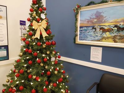A Christmas tree with red and gold decorations in the waiting room of Circle Medical clinic.