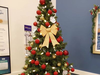 A Christmas tree with red and gold decorations in the waiting room of Circle Medical clinic.