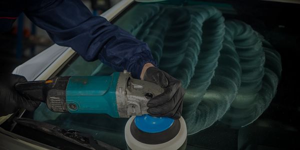 Removing scratches from glass with a handheld polisher