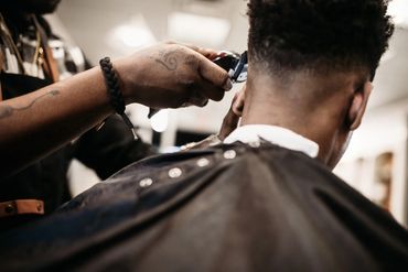 Barber giving a close haircut with clippers.