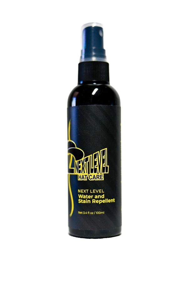 Black spray bottle labeled Next Level Hat Care water and stain repellent.