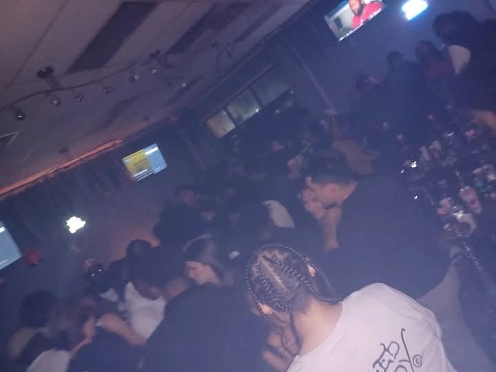 Woman dancing in front of the DJ booth with glitter confetti falling around.