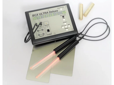 BCX Ultra Deluxe device with glowing electrodes and wooden handles.