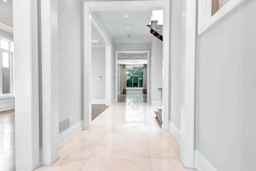 Spacious hallway in North York with polished tile flooring, white trim, and a transitional layout