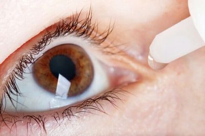 Close-up of an eye receiving eye drops.