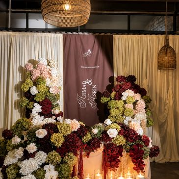 Floral backdrop with candles and drapes for a wedding.