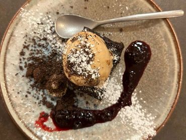 Juodojo šokolado pyragas, uogos, riešutai, ledai