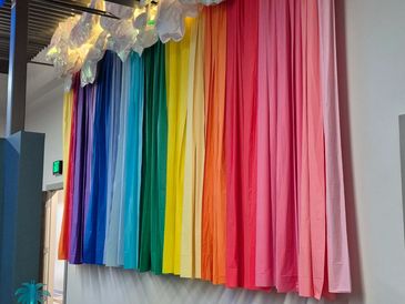 The back wall of the clinic is draped in floating rainbow colors