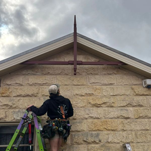 Ben Luff, director and head carpenter at Pixi Builds, working on a timber gable and stone wall in Me